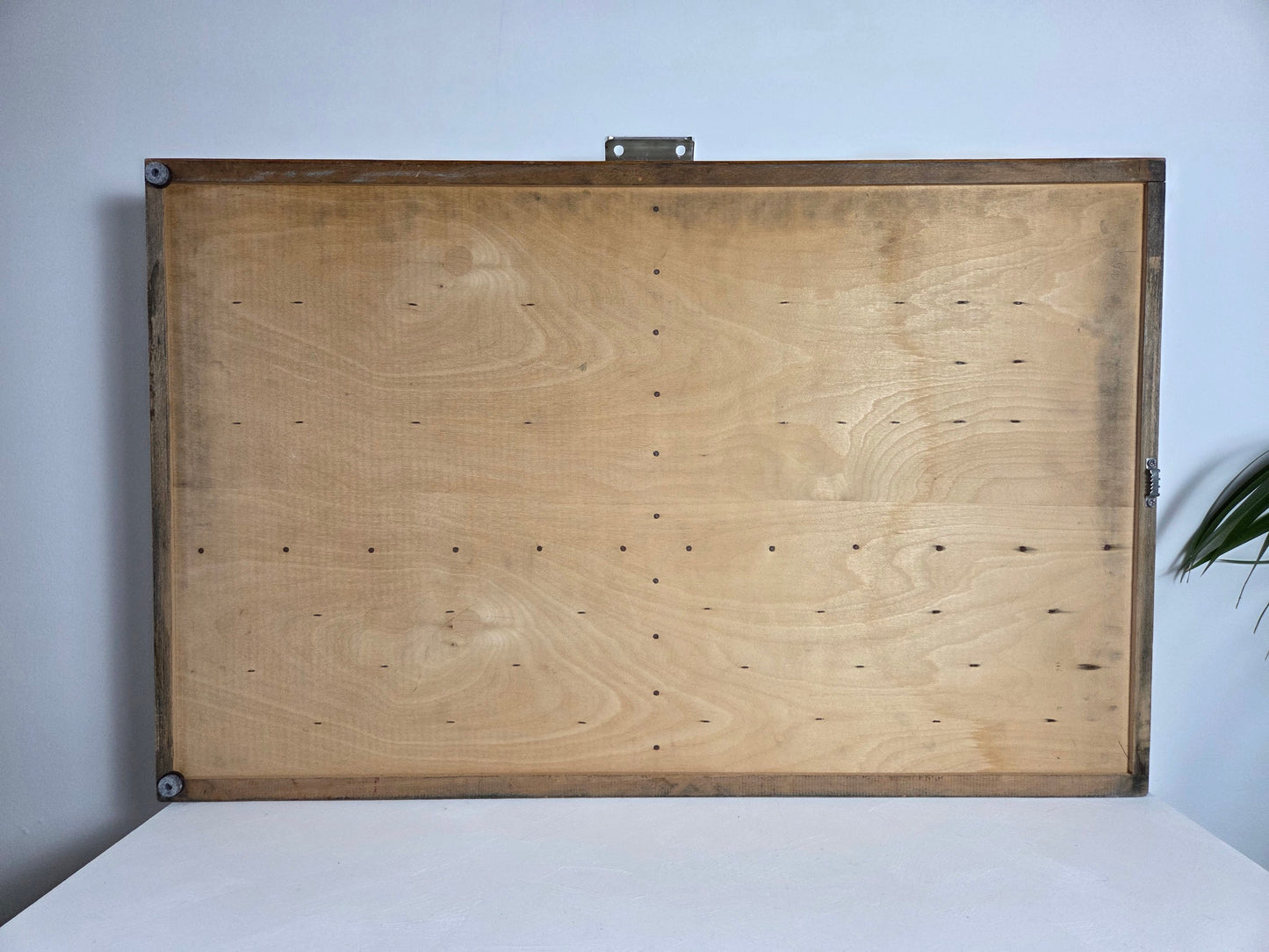 Lege vintage letterbak met 120 vakjes, staand tegen een lichte muur