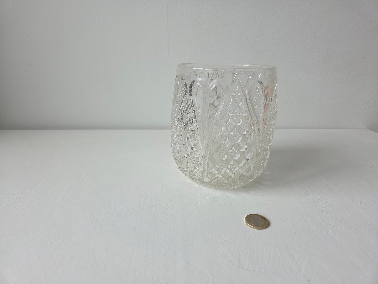 ronde glazen vaas met uitgebreid reliëf op de wand