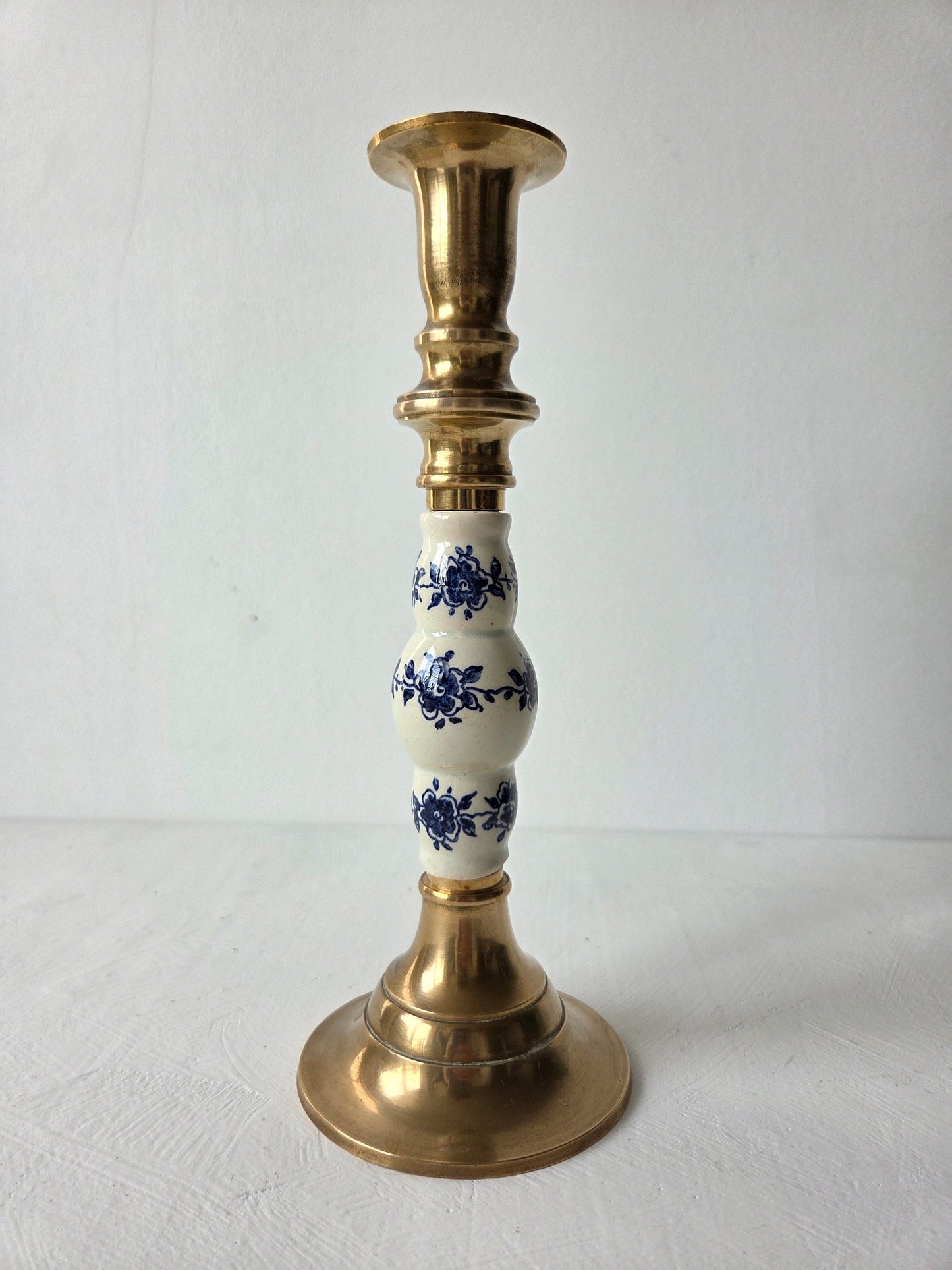 Vintage messing kandelaar met blauw-wit detail, aangeboden door D’Antan