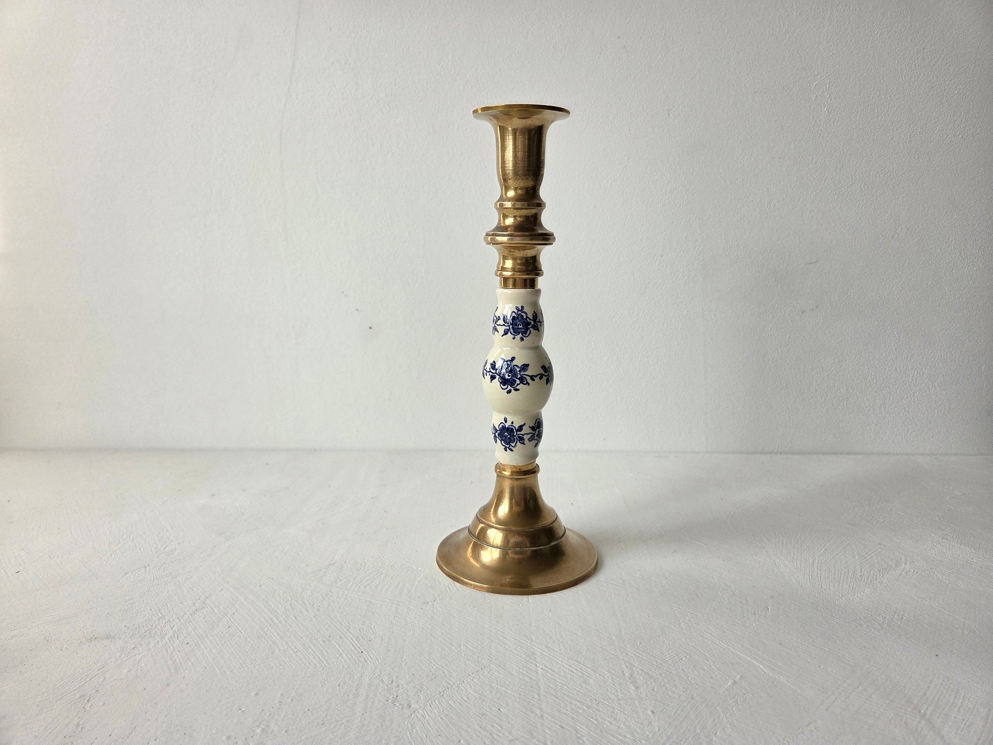 Slanke kandelaar van messing met Delfts blauw decor in het midden