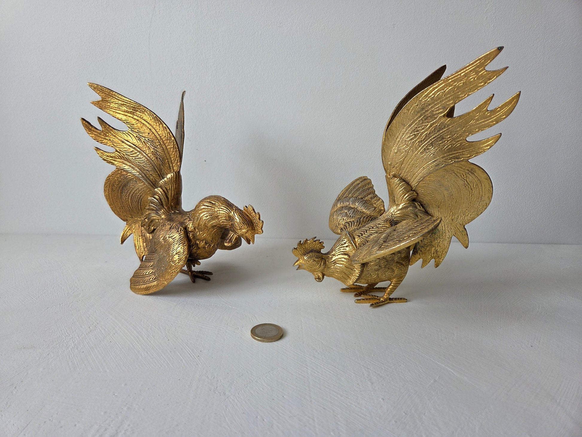 Goudkleurige haanbeelden van circa 16 cm hoog, staand tegenover elkaar