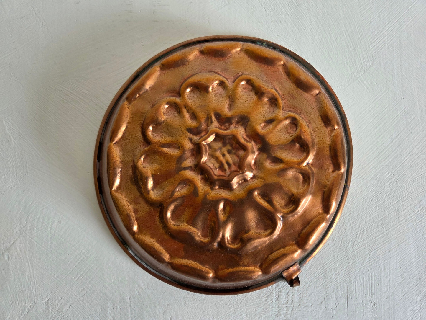 ronde koperen bakvorm bloemmotief reliëf patina vintage