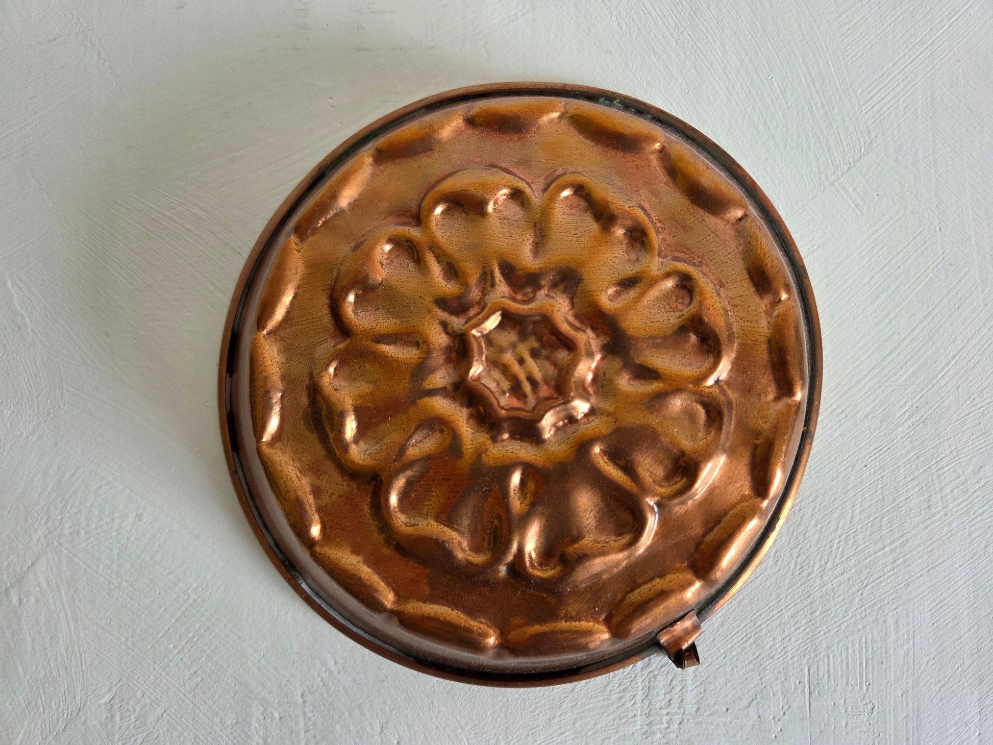 ronde koperen bakvorm bloemmotief reliëf patina vintage