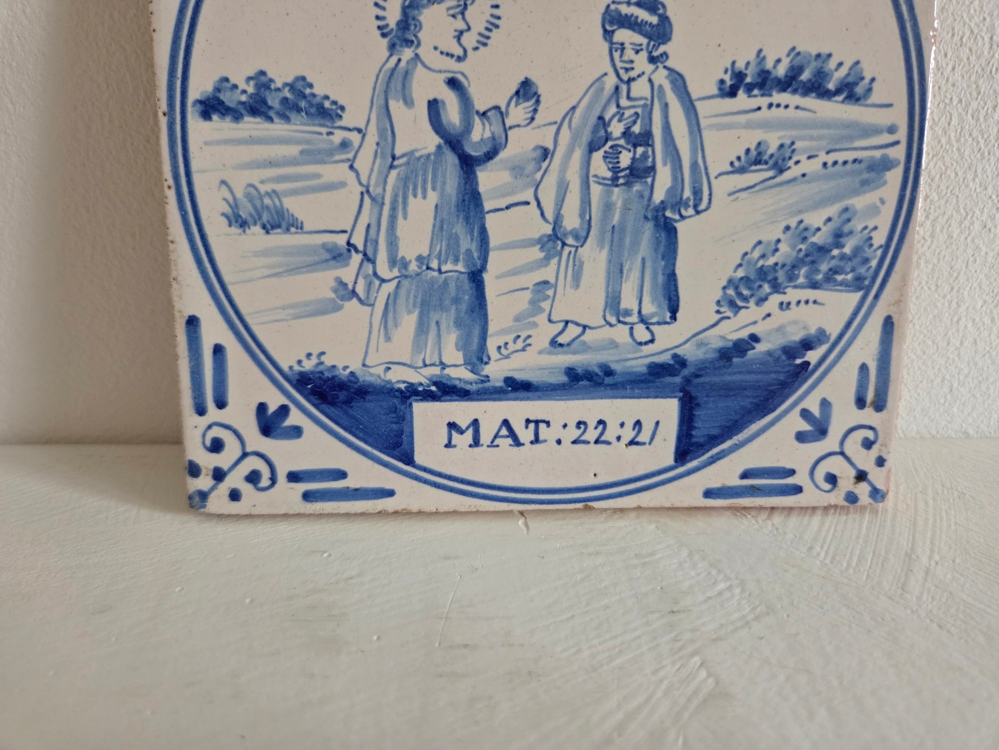 blauw witte bijbeltegel met belastingmuntje