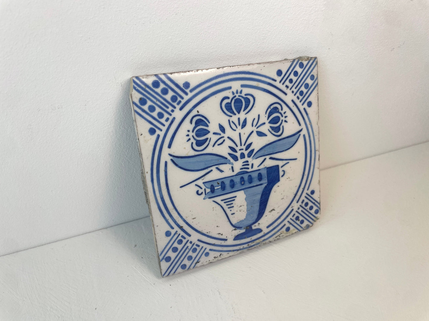 Delfts blauwe tegels met vaas en drie bloemen