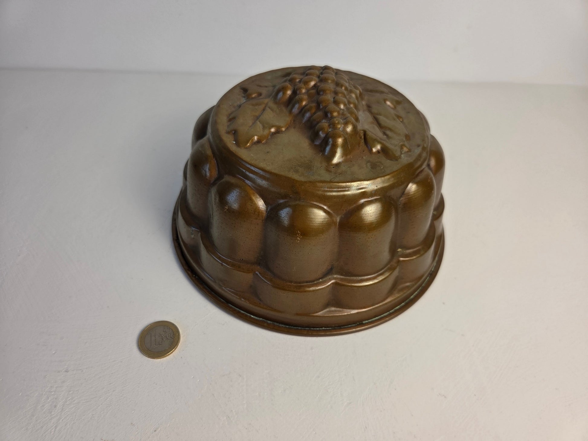 antieke koperen vorm met druivenmotief