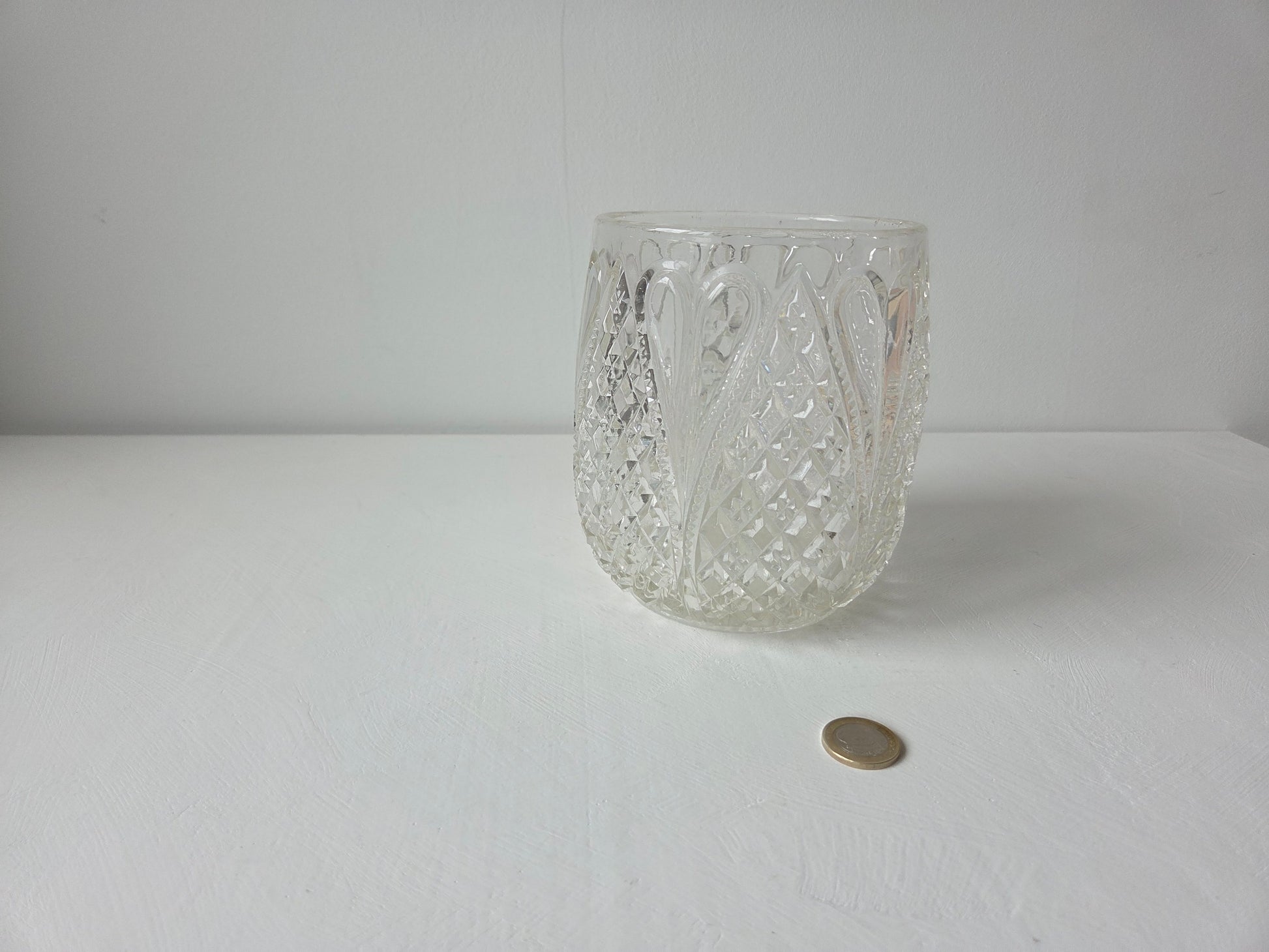 ronde glazen vaas met uitgebreid reliëf op de wand