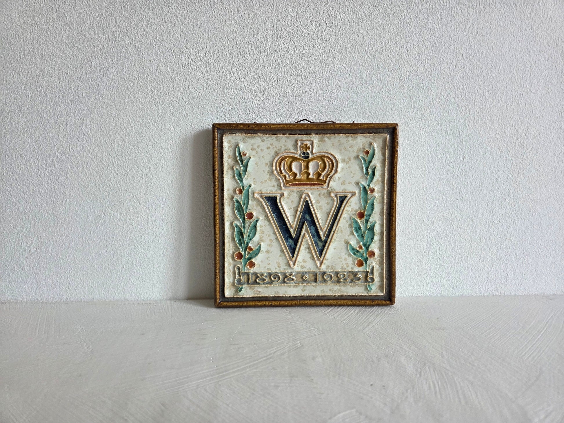 keramieken tegel Wilhelmina monogram kroon oranjeappeltjes