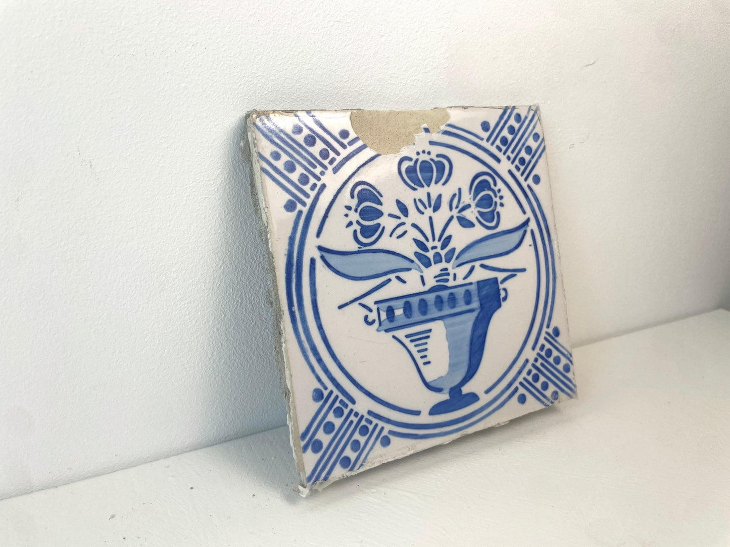 Vier oude keramiektegels met hoekmotieven