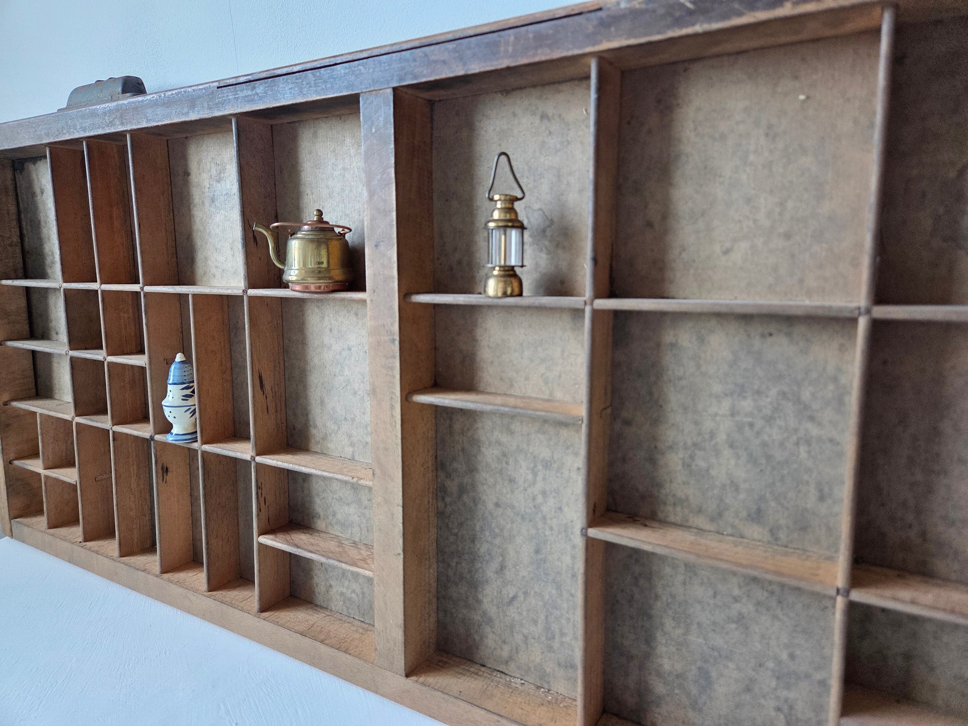 houten letterbak met 43 vakken aan de muur