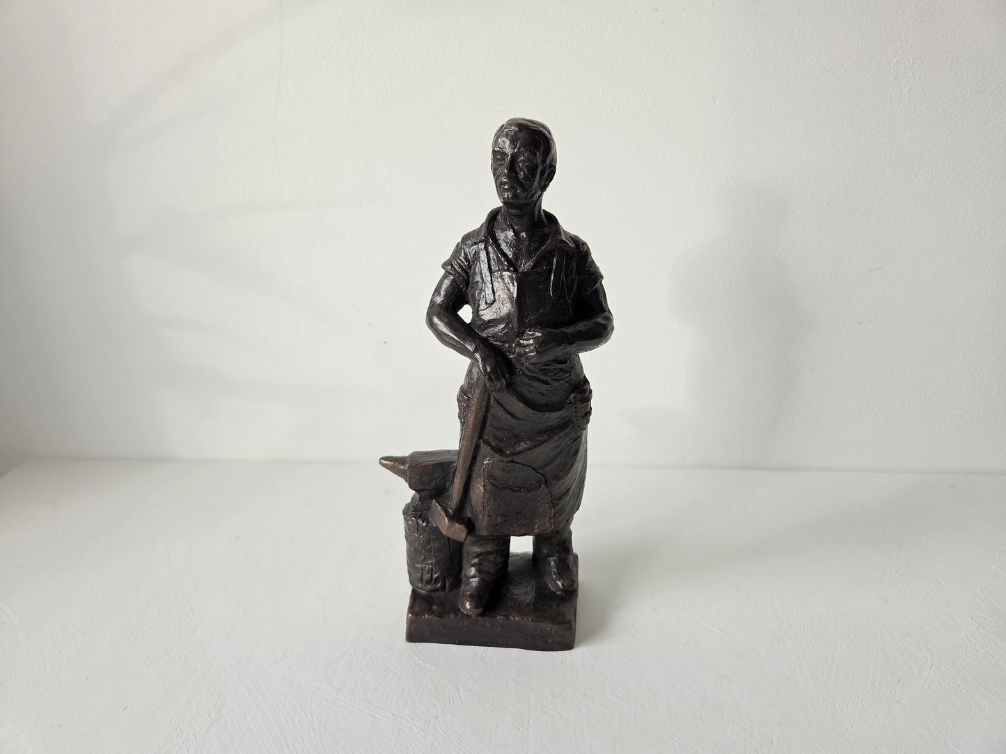 Smid sculptuur met aambeeld op witte achtergrond