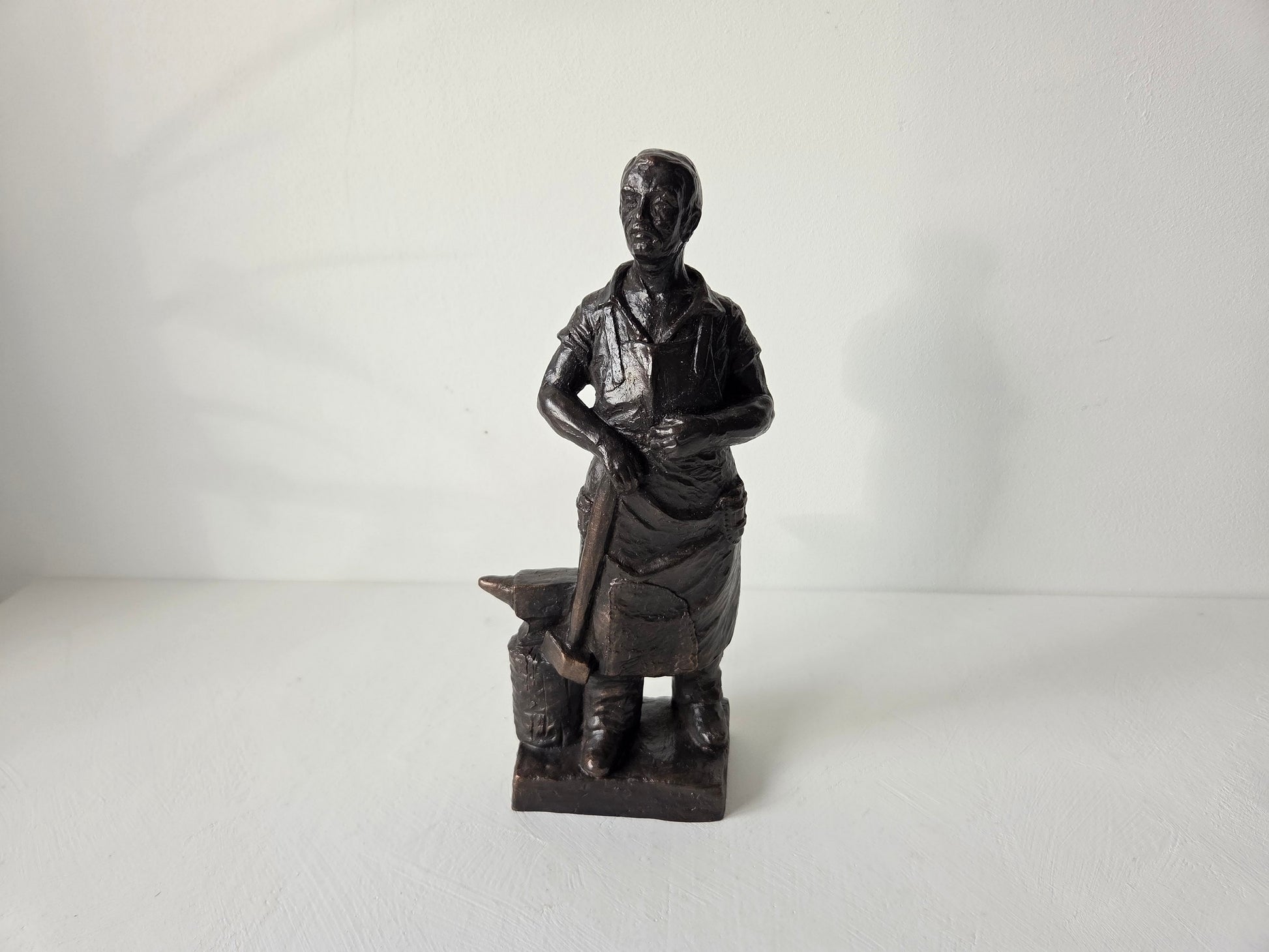 Smid sculptuur met aambeeld op witte achtergrond