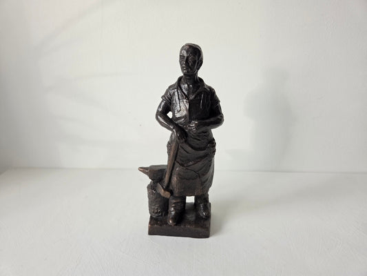 Smid sculptuur met aambeeld op witte achtergrond