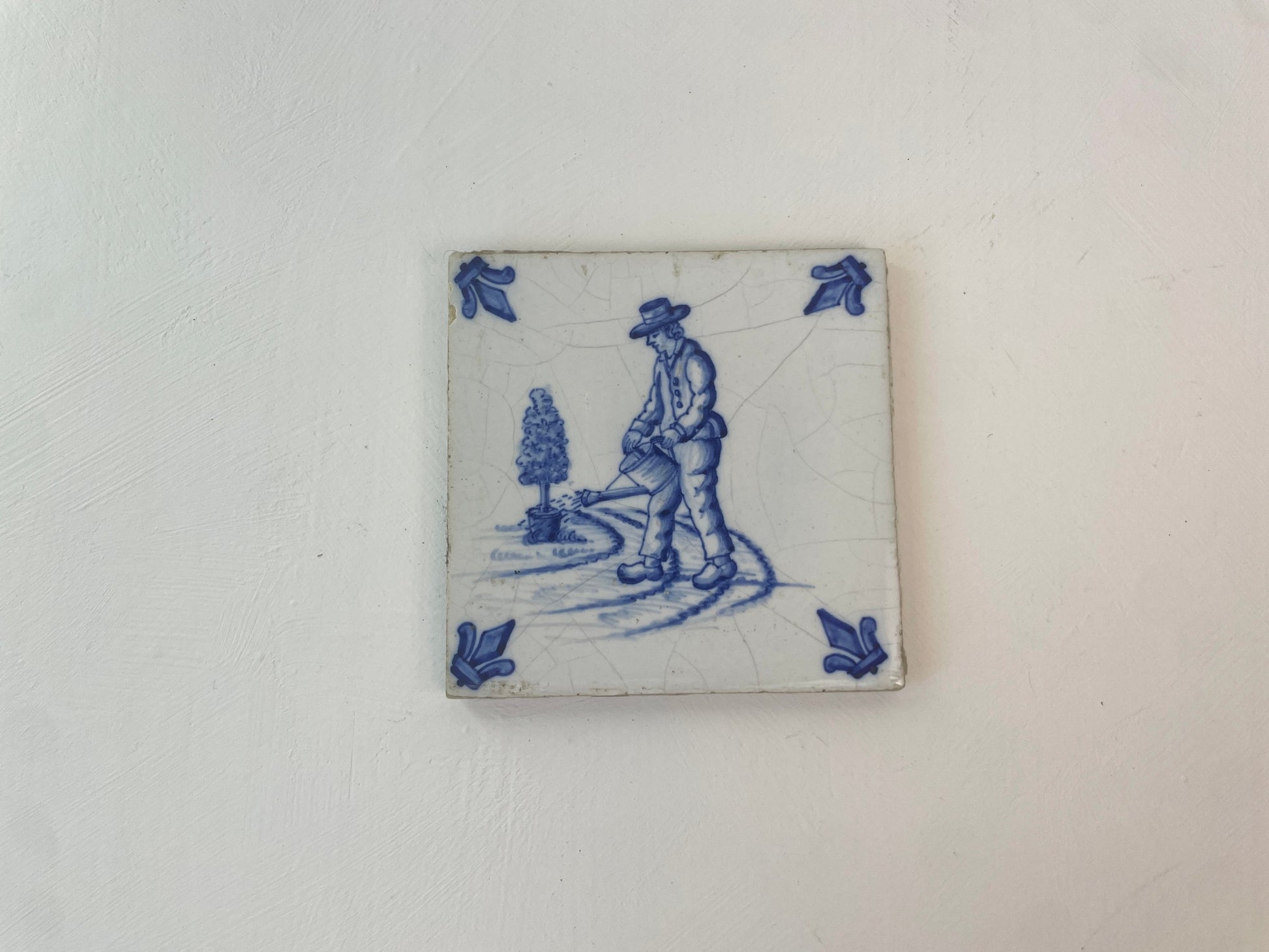 Detail van handgeschilderde tuinman op oud tegeltje