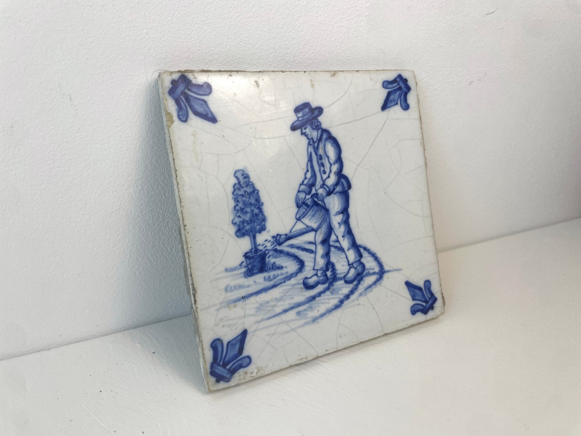 Tegel met tuinman en kleine boom