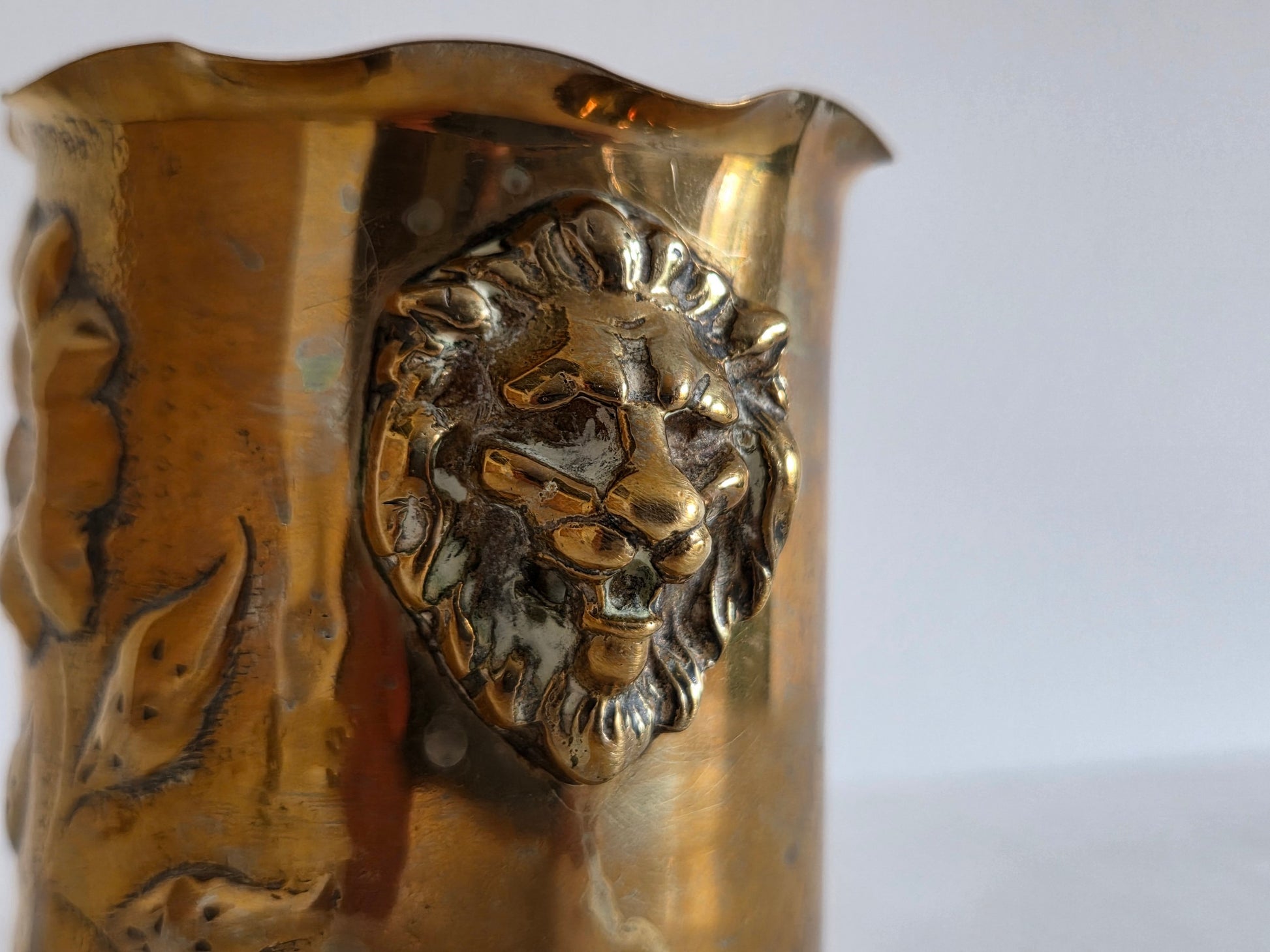 WOI souvenir messing beker leeuwenkoppen gedreven decor
